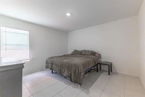 a spacious bedroom with a bed and a window