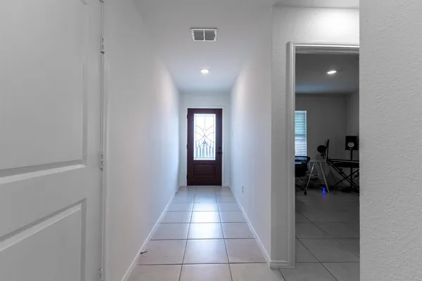 a view of a livingroom and a hallway to a livingroom and a window