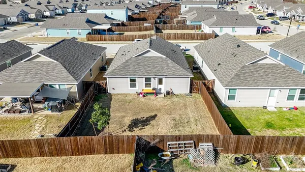 an aerial view of a house with swimming pool and large trees