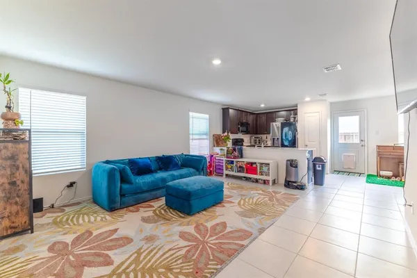 a living room with furniture and a open kitchen view