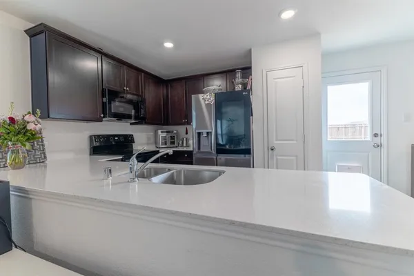 a kitchen with stainless steel appliances a sink and a refrigerator