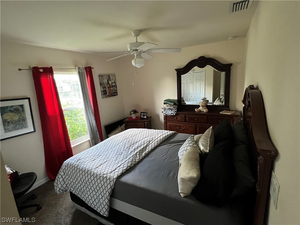 5018 Dolphin Circle LaBelle, FL 33935 - Photo 14 of 17 a bedroom with a bed and a chandelier