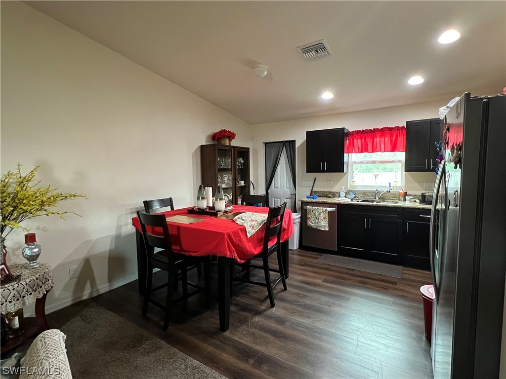 5018 Dolphin Circle LaBelle, FL 33935 - Photo 6 of 17 a kitchen with stainless steel appliances kitchen island granite countertop a stove a sink dishwasher and a microwave with wooden floor