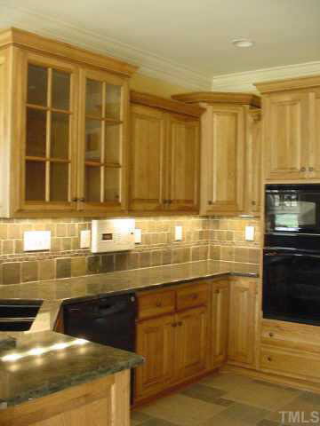 Kitchen features granite counter tops, under cabinet lighting, tiled floor, tile backsplash and custom hickory cabinets. Other