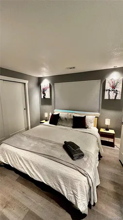 a bedroom with a bed and a painting on the wall