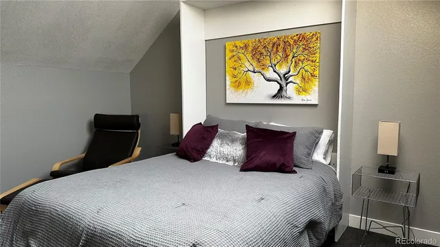 a bedroom with a bed and painting on the wall