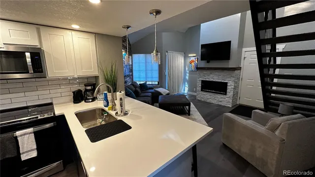 a kitchen with a stove a microwave a sink a refrigerator dining table and chairs