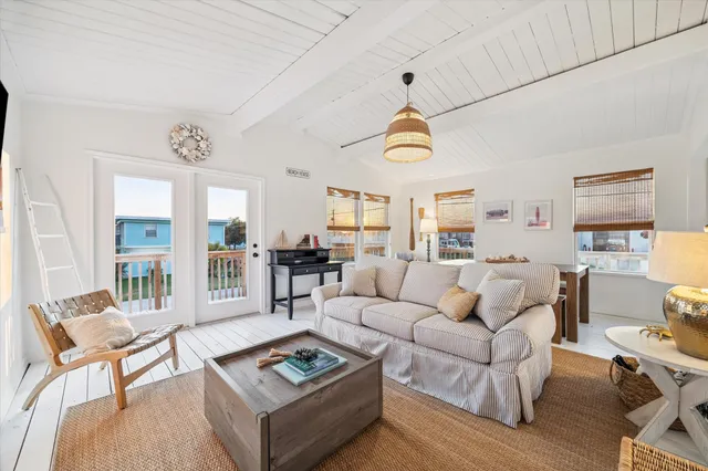 a living room with furniture kitchen view and a large window