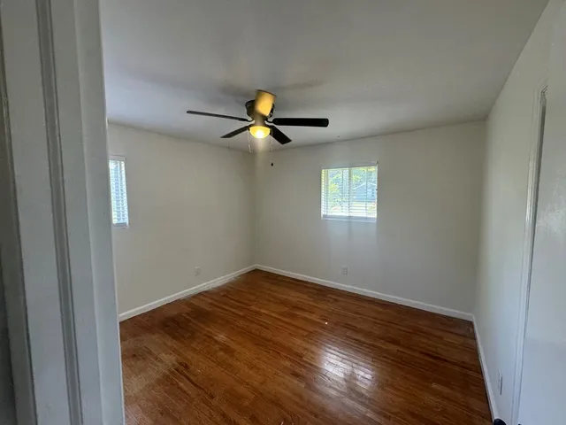 a view of room with wooden floor and ceiling fan