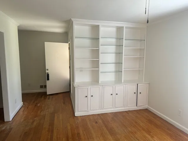 an empty room with cabinet and wooden floor