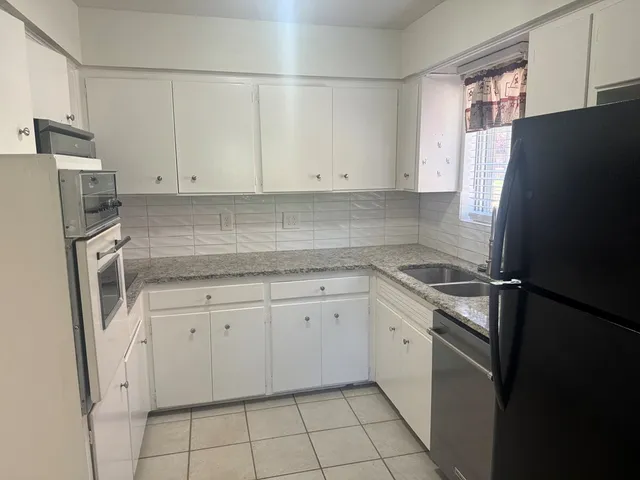 a kitchen with a refrigerator sink and cabinets