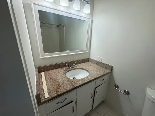 a bathroom with a granite countertop sink and a mirror