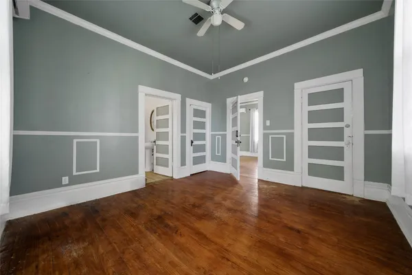 a view of an empty room with a window and wooden floor