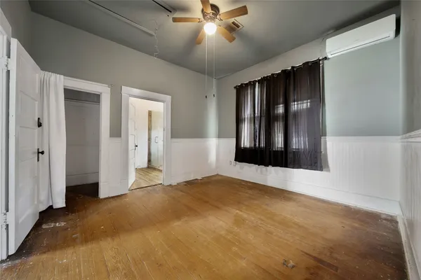 an empty room with closet and a ceiling fan