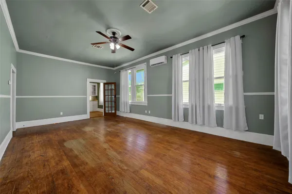 an empty room with wooden floor and windows