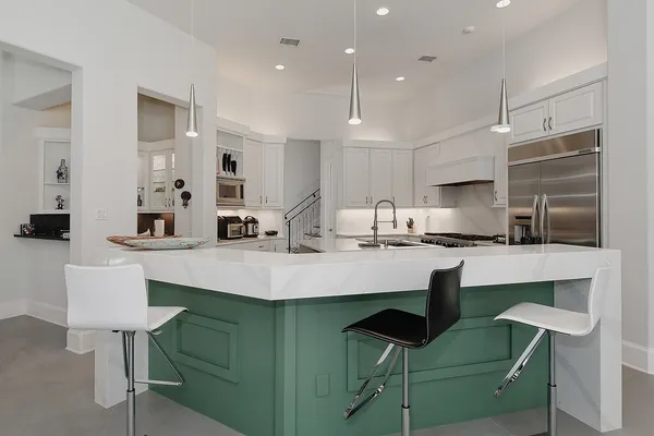 a kitchen with cabinets and chairs in it
