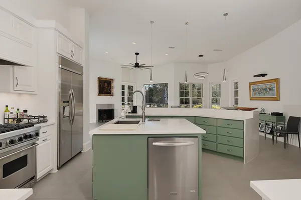 a kitchen with kitchen island granite countertop a sink stainless steel appliances and cabinets