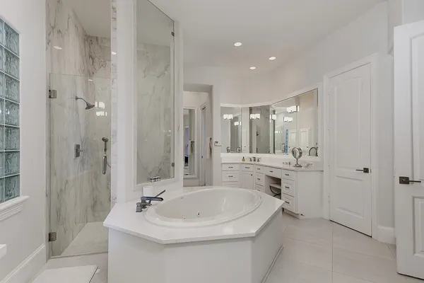 a bathroom with a bathtub shower sink mirror and toilet