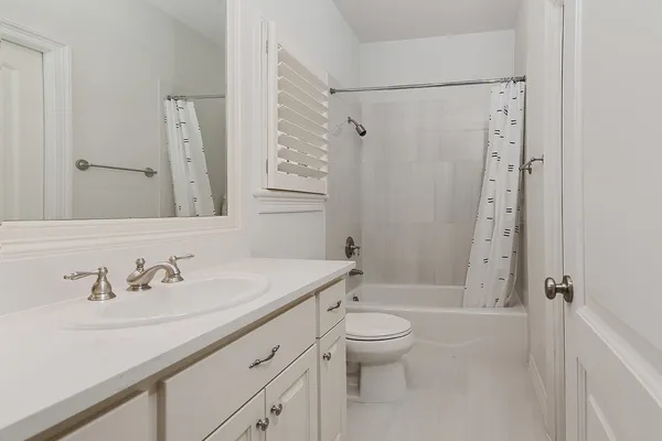 a bathroom with a sink a toilet and a large mirror