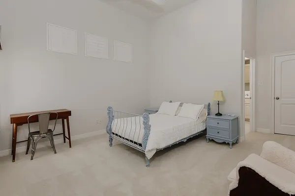 a spacious bedroom with a bed and a chair