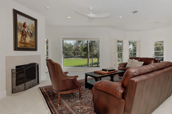 a living room with furniture a fireplace and a floor to ceiling window