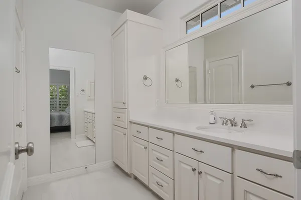 a spacious bathroom with 2 sink shower and a mirror