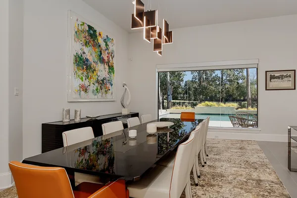 a view of a dining room with furniture a chandelier and wooden floor