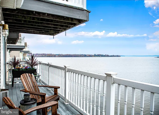 a view of a balcony with wooden floor next to a yard