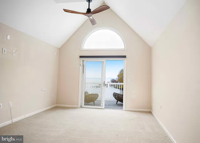 an empty room with a fireplace and a chandelier fan