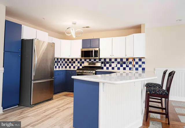 a kitchen with granite countertop a refrigerator stove and microwave