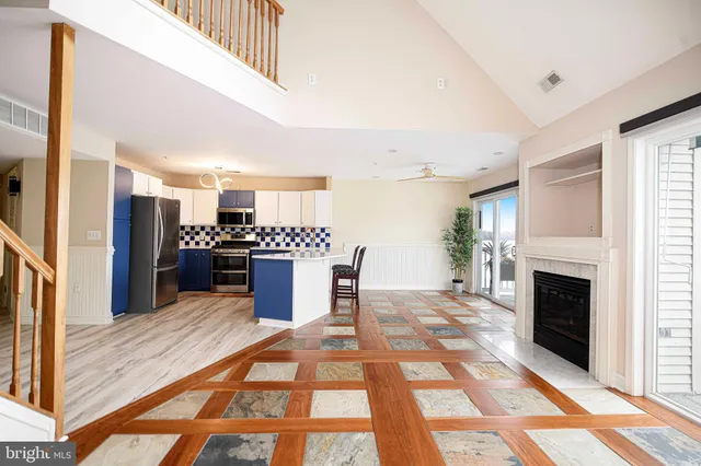 a kitchen with stainless steel appliances kitchen island granite countertop a refrigerator and a stove top oven