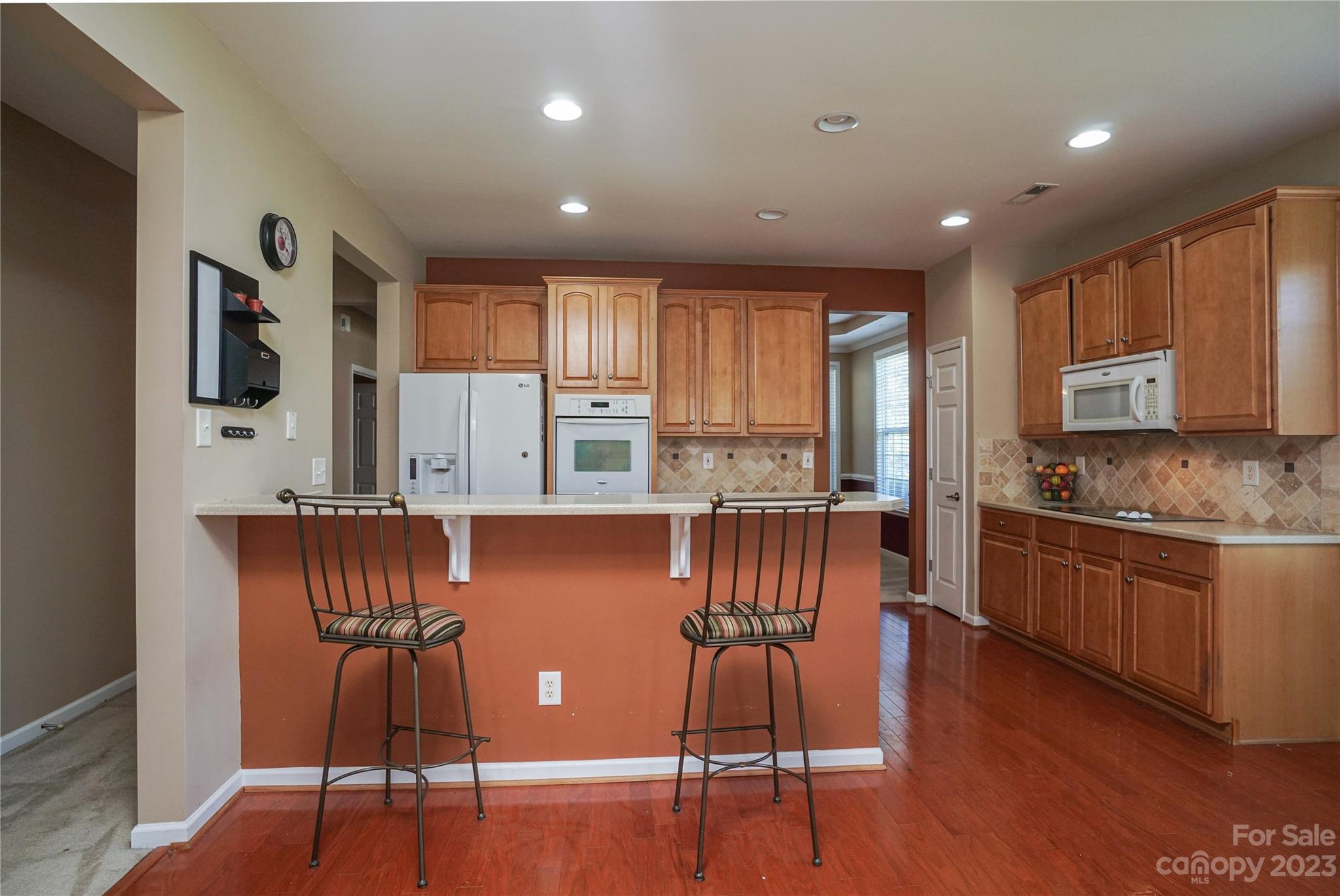 662 Amethyst Circle Fort Mill, SC 29708 - Photo 19 of 34 a kitchen with stainless steel appliances granite countertop a stove top oven a sink a dining table and chairs with wooden floor
