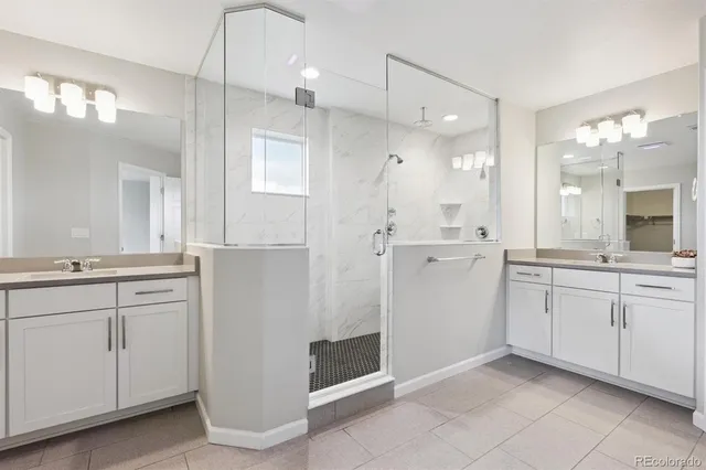 a bathroom with a granite countertop sink mirror and a shower
