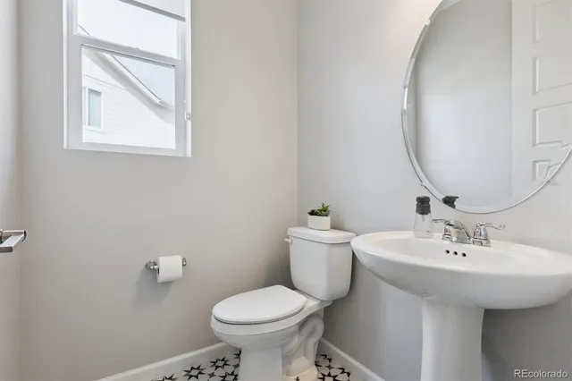 a bathroom with a sink toilet and a mirror
