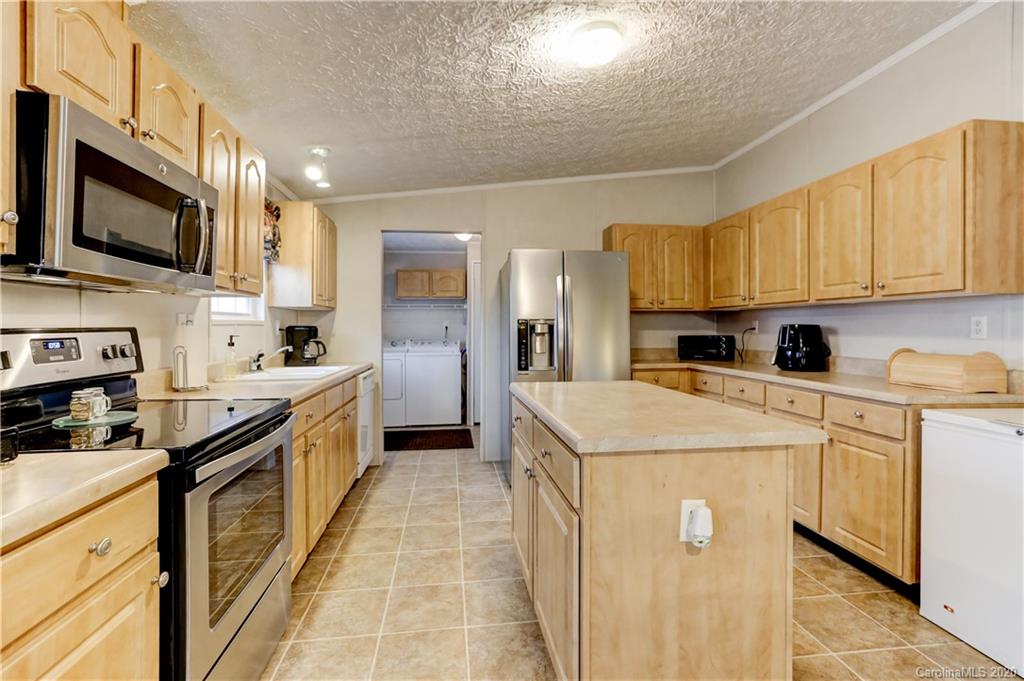 687 Fayette Road York, SC 29745 - Photo 13 of 48 a kitchen with stainless steel appliances granite countertop a stove top oven a refrigerator a sink and dishwasher with white cabinets