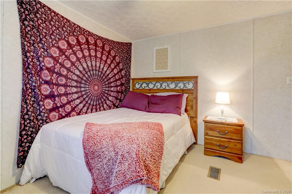 687 Fayette Road York, SC 29745 - Photo 25 of 48 a bedroom with a bed and a lamp with the wooden floor