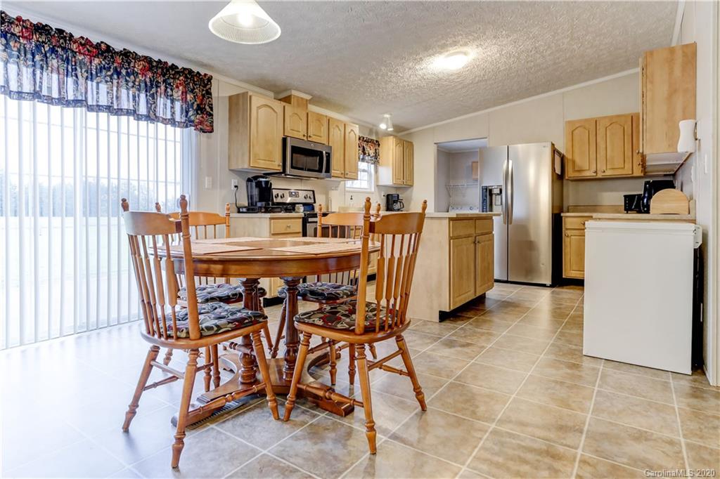 687 Fayette Road York, SC 29745 - Photo 9 of 48 a kitchen with a table chairs microwave and cabinets