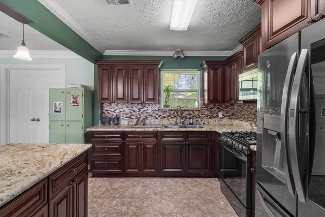 a kitchen with stainless steel appliances granite countertop a sink stove and refrigerator