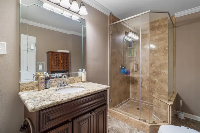 a bathroom with a granite countertop sink a mirror and a shower