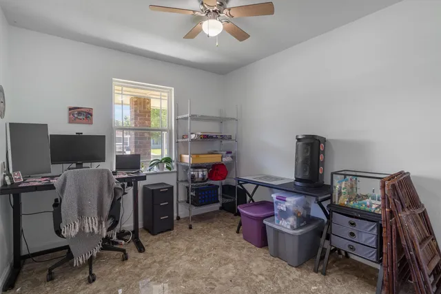 a view of a workspace with furniture and a window