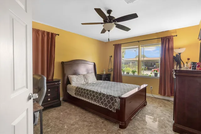 a bed sitting in a spacious bedroom next to a window