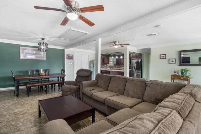 a living room with furniture kitchen view and a chandelier