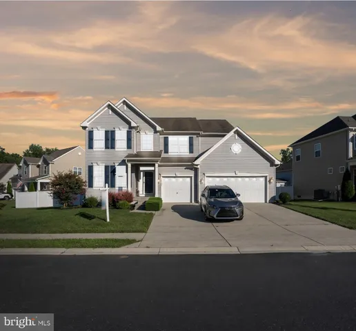 a front view of a house with a garden and parking