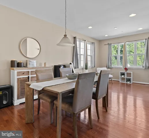 a living room with furniture wooden floor and a kitchen view