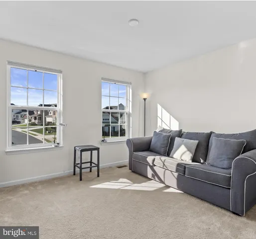 a bedroom with a bed couch and a large window