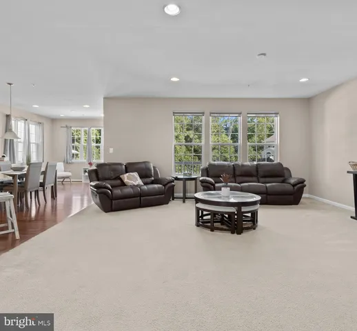 a living room with furniture a table and a large window