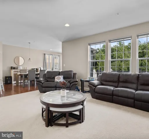 a living room with furniture and a dining table with kitchen view
