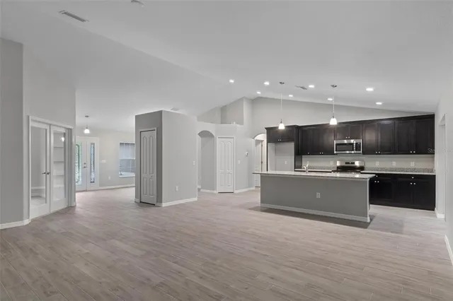 a view of kitchen with kitchen island stainless steel appliances refrigerator stove microwave and cabinets