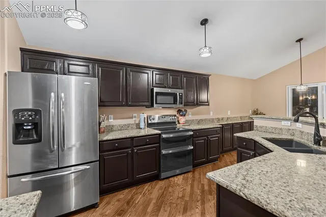 a kitchen with granite countertop stainless steel appliances and wooden cabinets