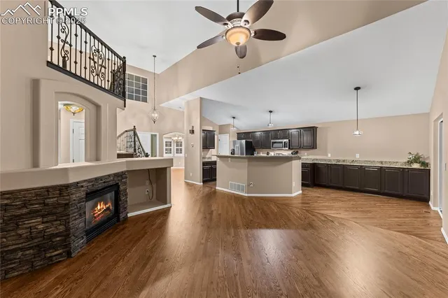 a large kitchen with stainless steel appliances kitchen island a large counter top and a fireplace